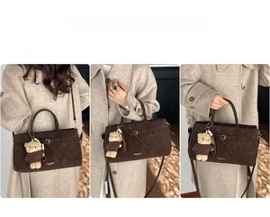 Three-way view of brown frosted leather handbag with bear charm and adjustable strap