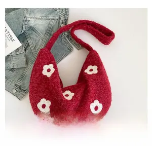 Vue détaillée du sac à bandoulière en peluche rouge avec motifs fleurs blanches dessus