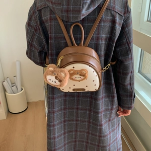 Detailed view of mini brown leather backpack with bear embroidery and polka dot patterns