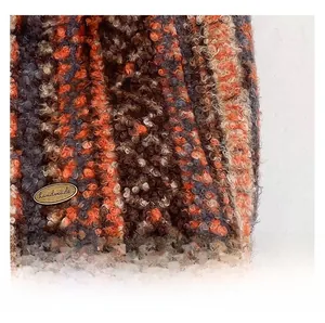 Macro shot of multi-color blended wool fabric with an oval handmade metal tag