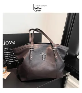 Detail view of coffee brown retro tote bag with cross charm and star rivets