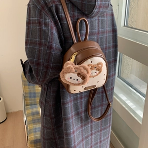 Detail of mini backpack with brown polka dots and a cute plush teddy bear charm