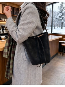 Gros plan sur le sac fourre-tout noir en cuir mat avec cordon de serrage et décor de café