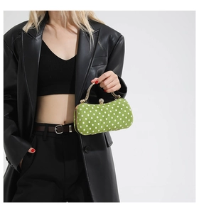 Detail of green polka dot box bag with gold handle and sparkling crystal clasp