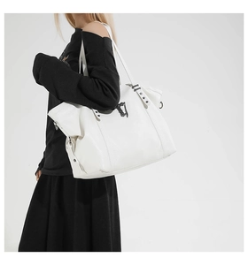 Close-up of white Gothic tote bag showing black star rivets and metallic chain details