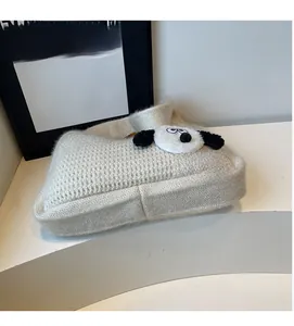 Detailed texture of cream knit handbag featuring a cute plush 3D puppy patch design