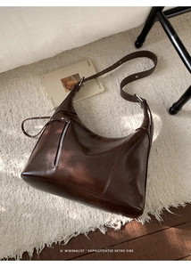 Detail of dark brown crescent bag in glossy oil wax leather with silver zip pocket