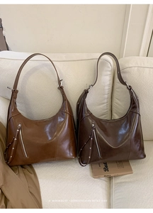 Detail of vintage Hobo bags in brown and coffee leather with tassel zipper and silver studs