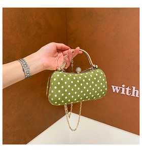 Macro detail of velvet olive green polka dot box bag with gold chain and diamond clasp