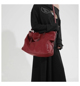 Detail of burgundy leather tote bag with star studs and adjustable shoulder strap