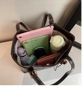 Deep brown tote bag interior showing large capacity for tablets and daily items