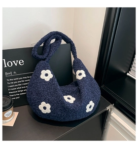 Détail d'un sac dumpling en polaire bleu marine avec broderie de fleurs blanches