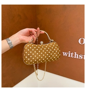 Close-up of retro brown polka dot bag featuring golden metal handle and bead details