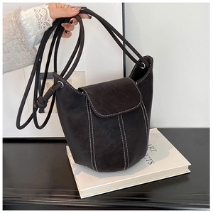 Detail view of black vintage bucket bag with contrast white stitching and matte finish