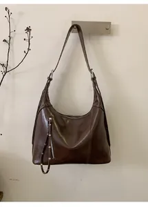 Detailed close-up of dark brown vintage hobo bag with metallic zippers and rivet details