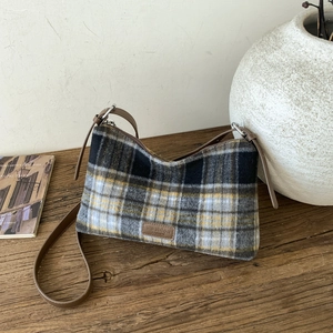 Vue détaillée de la texture du sac à carreaux avec étiquette de mode en cuir marron