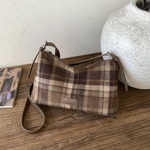 Vue détaillée du sac cabas en laine à carreaux avec bandoulière sur table en bois rustique