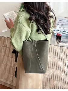 Vue détaillée du sac seau en cuir vert mousse avec bandoulière longue et grain fin du cuir
