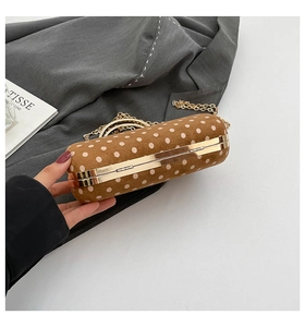 Detail view of brown suede box bag with white polka dots and gold chain strap