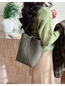 Détail du sac seau en daim vert olive avec cordon de serrage et design minimaliste élégant