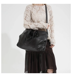 Detail of soft black leather tote bag with silver star rivets and reinforced stitching
