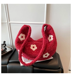 Détail du sac à bandoulière en peluche tricotée rouge avec broderies de fleurs blanches