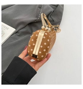 Close-up of brown suede polka dot bag with diamond metal handle and gold chain strap