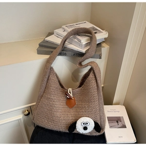 Detail of brown chunky knit tote bag with horn buckle and cute plush animal charm