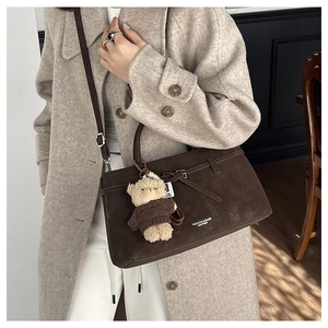 Detail of dark brown faux suede tote bag with teddy bear charm and fashion text