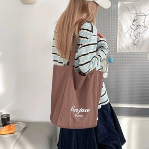 Detailed view of large brown cotton canvas tote bag with Our fave Party lettering