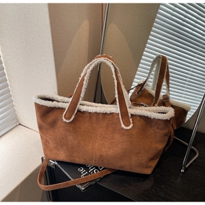 Gros plan d'un sac cabas en daim marron avec bordure en similicuir blanc moutonné