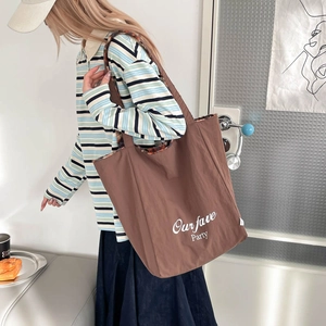 Large brown canvas tote bag with white lettering and leopard print handle detail