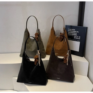 Detail of hobo tote bags in four colors with bear charms and embossed logo details