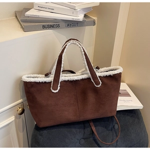 Détail d'un sac cabas en daim marron avec bordure en fausse fourrure blanche chic