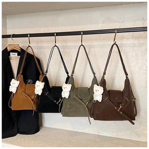 Close-up of retro tote bags in brown, black, green, and coffee with bear charms