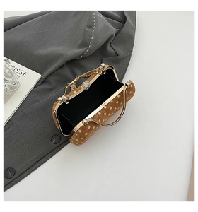 Detailed interior of the brown polka dot clasp bag with golden handles and pearl clasp