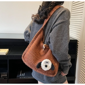 Detailed knit shoulder bag with cute cartoon dog patch on a brown textured tote