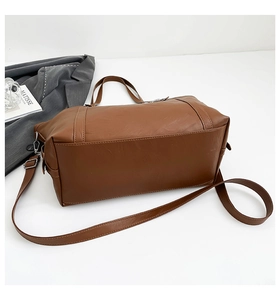 Detail of brown PU leather tote bag with reinforced handles and adjustable strap