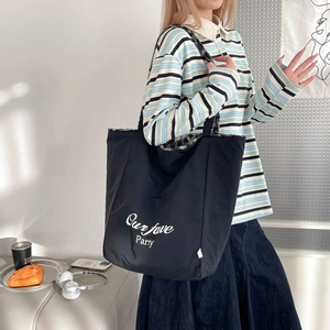 Detail of black tote bag featuring white party lettering and leopard print plush lining