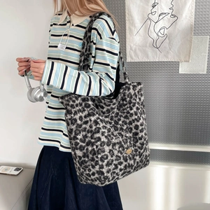 Detailed view of plush leopard print tote bag featuring soft faux fur and metal brand charm