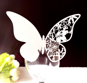 Détail du marque-place papillon découpé au laser blanc avec motifs floraux creux