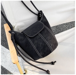 Detailed view of black bucket bag with white contrast stitching on a camping chair