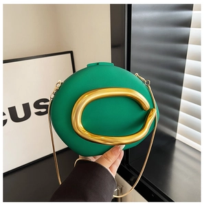 Detail of green acrylic oval evening clutch with gold metal C buckle and snake chain