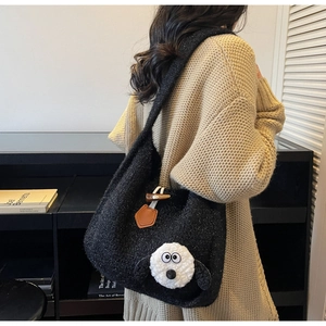 Close-up of black knit tote bag featuring a cute white cartoon dog and toggle closure