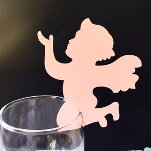 Pink laser-cut angel cup card for festive table decoration on transparent glass