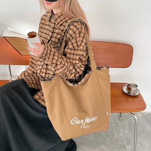 Detail of khaki tote bag with leopard print faux fur lining and party slogan