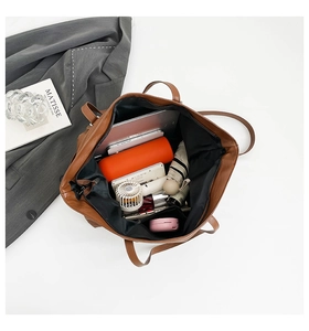Internal view of large brown tote bag showing capacity for tablet, umbrella, and daily items