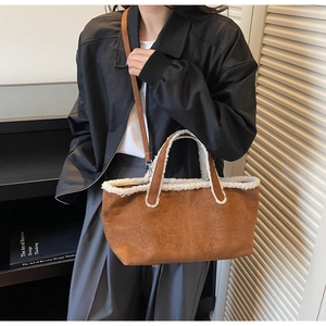 Détail du sac bandoulière en daim avec bordure en similicuir mouton et sangle réglable