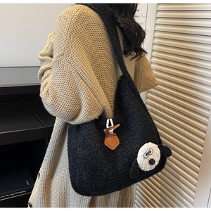 Detailed view of the black fleece tote bag with a cartoon dog and horn buckle closure