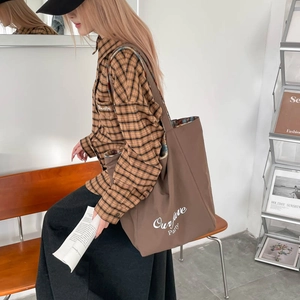 Deep brown tote bag with 'Our fave Party' text shown in a cozy lifestyle setting